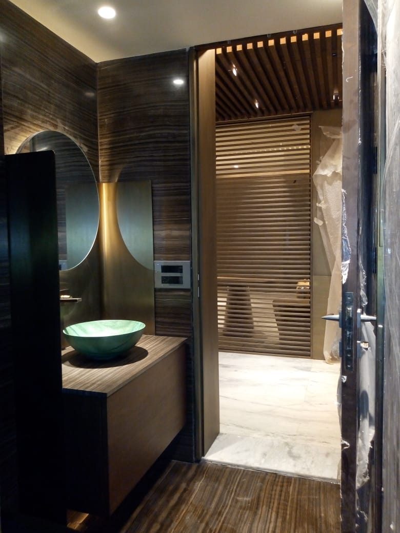 Elegant washroom with a round backlit mirror and green ceramic basin